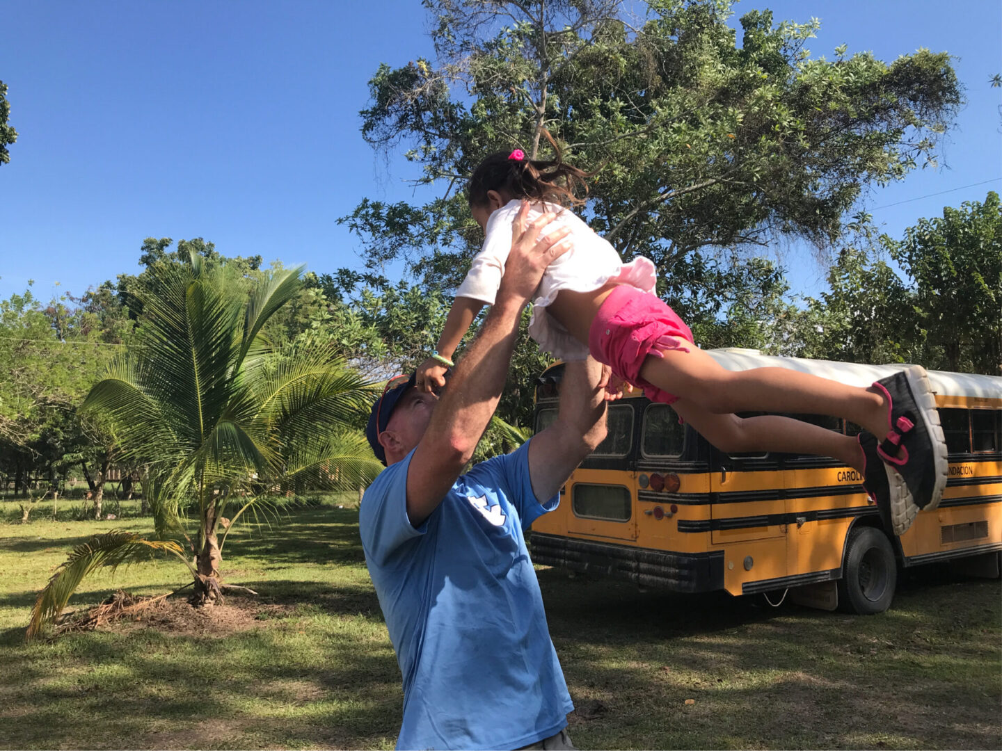 A man throwing a little girl up to the sky