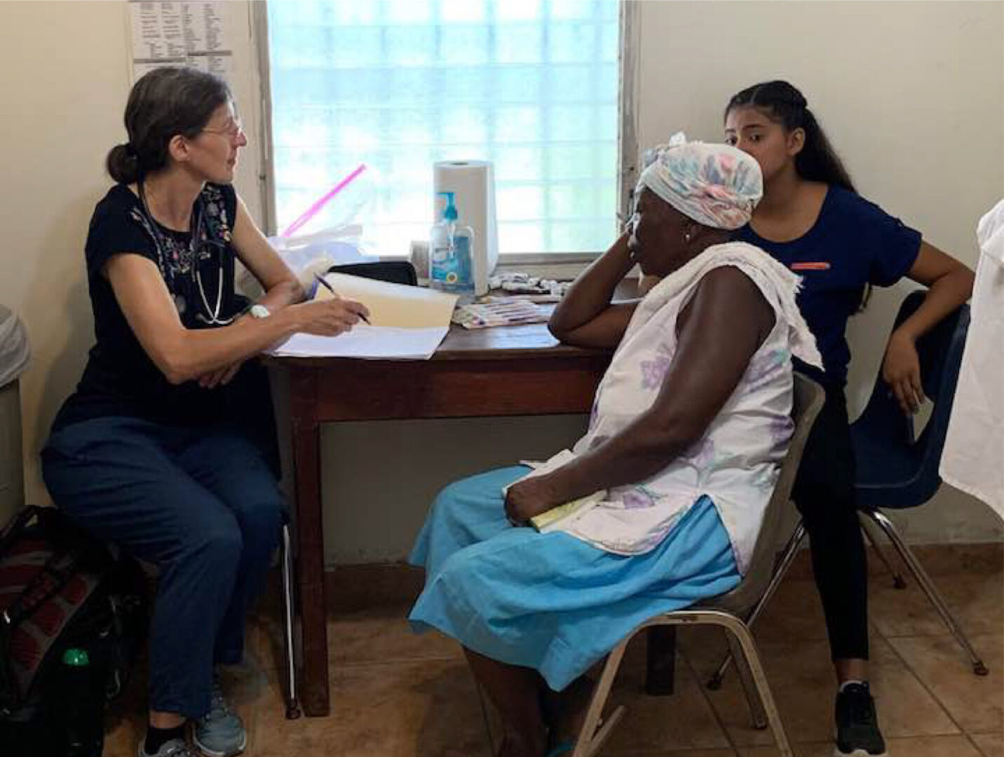 An older woman getting her check up, accompanied by a younger woman