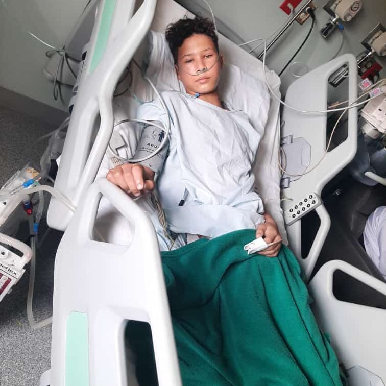 Patient in hospital bed with oxygen tubing
