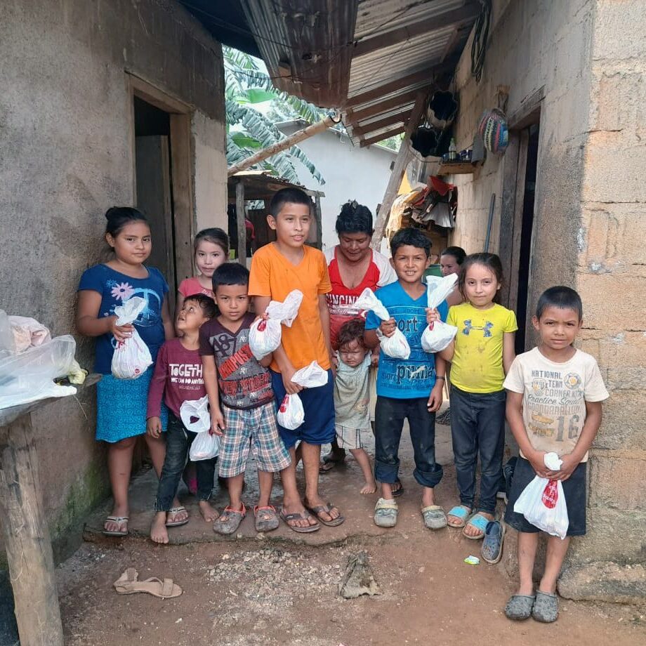 Honduran children clutch small bags of food