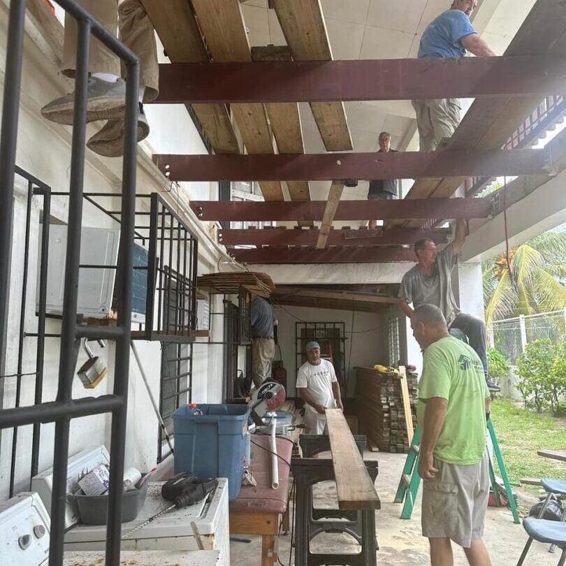 Workers installing wooden beams and scaffolding outdoors